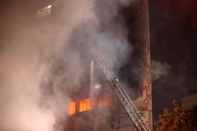 Un bombero intenta extinguir un incendio en un edificio en el centro de Sao Paulo, Brasil. 1 de mayo de 2018. REUTERS / Leonardo Benassatto