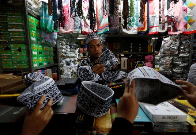 A man sells prayer caps on the eve of the Muslim fasting month of Ramadan at a traditional market in Jakarta, Indonesia, May 16, 2018. REUTERS/Willy Kurniawan