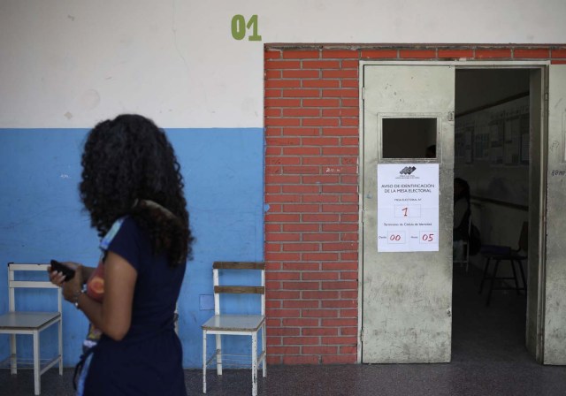 A woman walks past a nearly empty polling station during the presidential election in Caracas, Venezuela, May 20, 2018. REUTERS/Adriana Loureiro