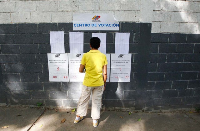 A woman checks electoral lists at a polling station during the presidential election in Caracas, Venezuela, May 20, 2018. REUTERS/Christian Veron