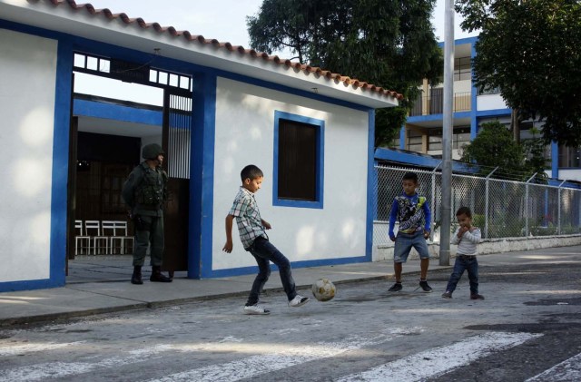 Youths kick a ball in front of a polling station during the presidential election in San Cristobal, Venezuela, May 20, 2018. REUTERS/Carlos Eduardo Ramirez