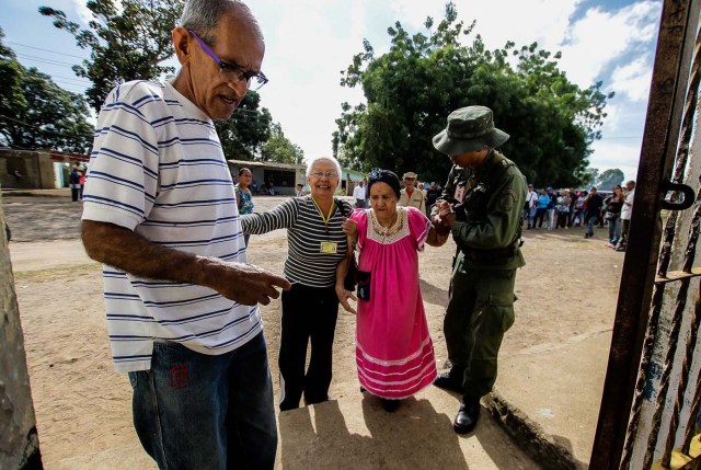 A Venezuelan is assisted while waiting with others to vote at a polling station during the presidential election in Puerto Ordaz, Venezuela, May 20, 2018. REUTERS/William R. Urdaneta