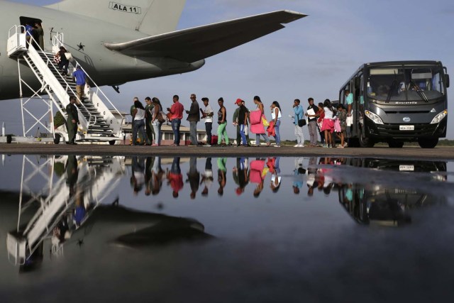 BSL03. BOA VISTA (BRASIL), 04/05/2018.- Venezolanos ingresan a un avión en el aeropuerto de Boa Vista (Brasil) hoy, viernes 4 de mayo de 2018. Las autoridades brasileñas trasladaron desde Boa Vista, el principal punto de acogida de la inmigración venezolana, a 233 ciudadanos de esa nación caribeña que han decidido intentar rehacer sus vidas en Sao Paulo y Manaus. Todos partieron en el mismo avión de la Fuerza Aérea Brasileña y 164 desembarcarían en la primera escala, en la amazónica Manaus, en tanto que los otros 69 seguirían viaje hasta Sao Paulo, la ciudad más poblada del país, donde esperan dejar definitivamente atrás la crisis económica, social y política en que se ha hundido Venezuela. EFE/Joédson Alves