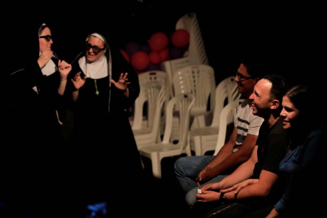 Los asistentes reaccionan durante una obra en un teatro improvisado en una antigua sala de bingo en Caracas, Venezuela el 2 de junio de 2018. Foto tomada el 2 de junio de 2018. REUTERS / Marco Bello