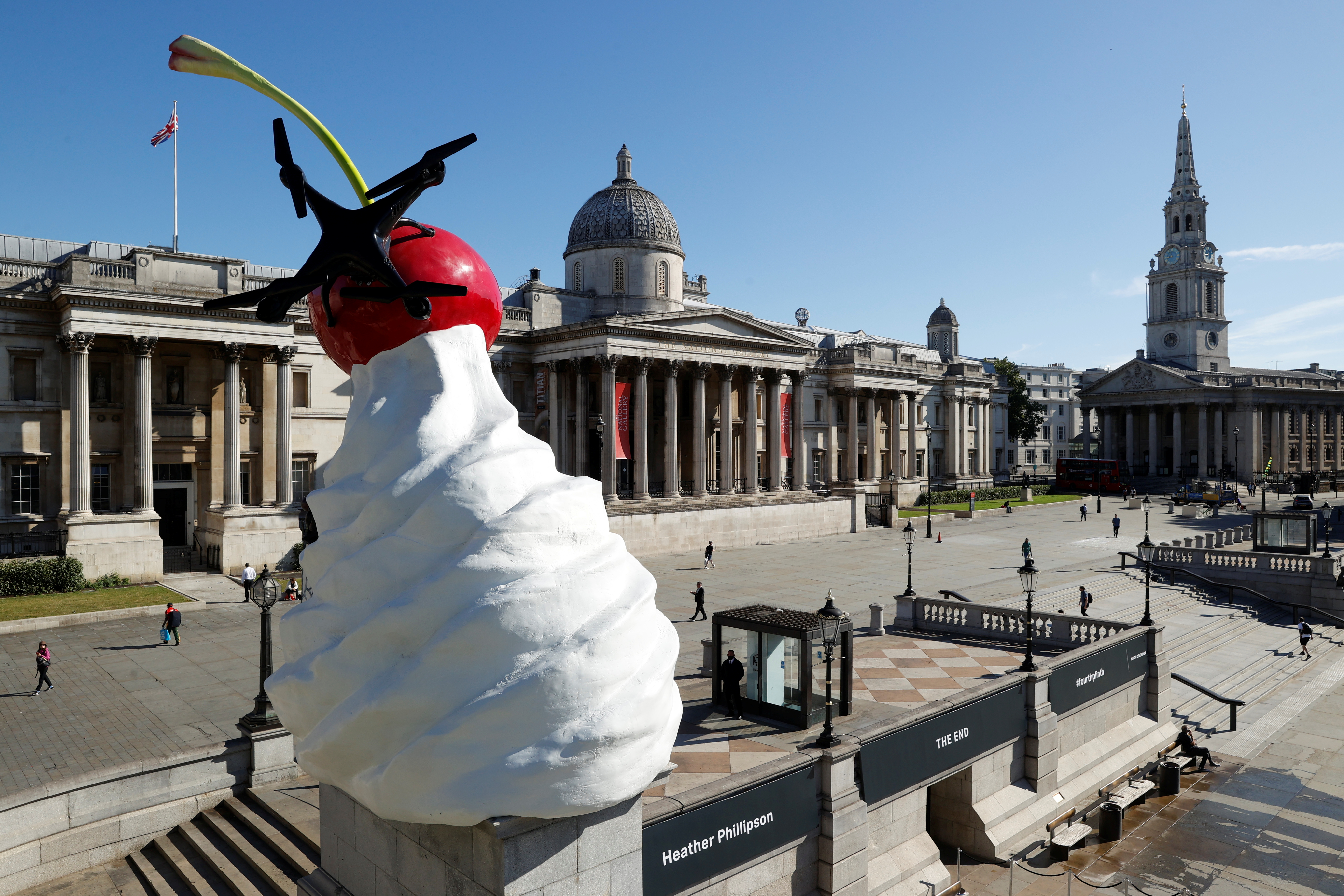 Revelan escultura de cereza gigante con crema, mosca y dron en Trafalgar Square de Londres