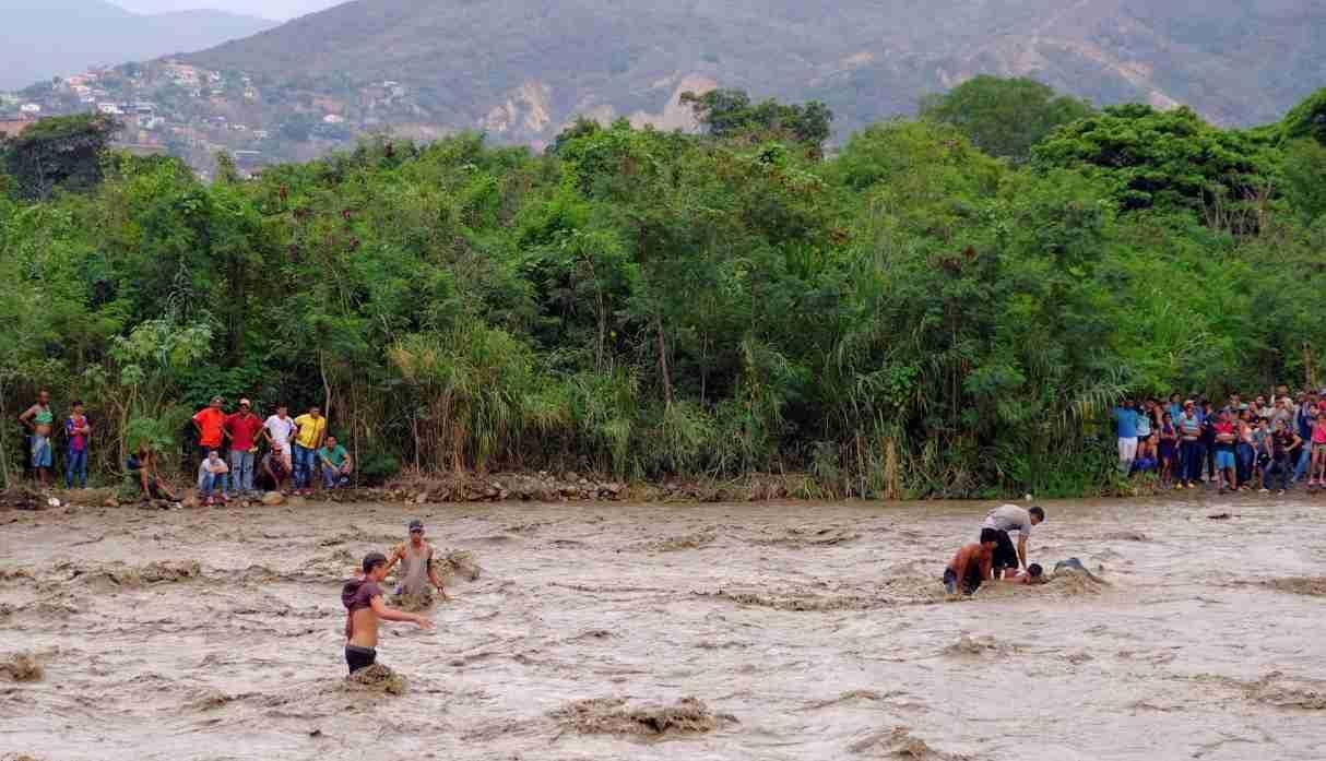 Venezolanos deciden tomar el riesgo de cruzar un río crecido y salir del país