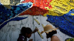 Venezuelan mural artist uses recycled plastic to light up Caracas suburb