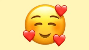 El verdadero significado del emoji más usado de WhatsApp: para qué se usa la carita rodeada de corazones