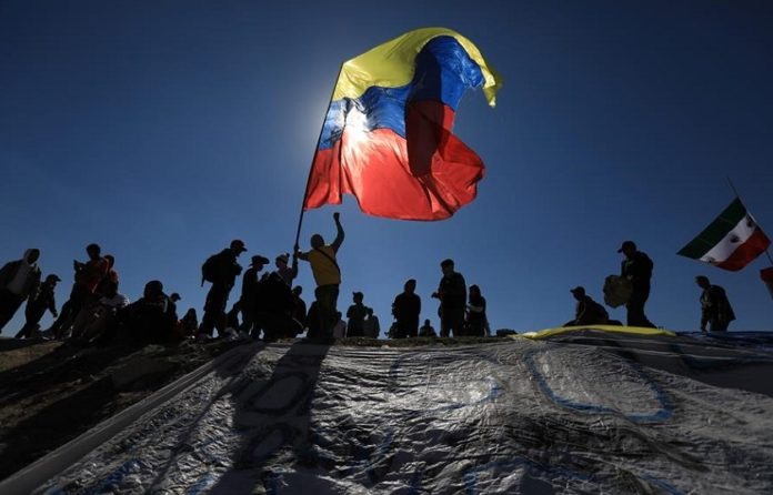 Venezolanos arman cuartos con tablas a la espera de su cita para refugio en EEUU